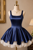 Navy blue dress with white ruffled hem on a mannequin against a neutral wall.
