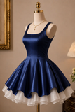 Navy blue dress with white ruffled hem on a mannequin against a neutral wall.