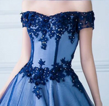 Navy blue off-shoulder dress with floral lace details on a plain background