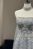 Silver beaded evening gown on a mannequin against a neutral background
