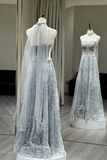 Silver evening gown with a long train on a mannequin against a neutral background