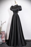 Black evening gown on a mannequin against a white background