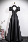 Black evening gown on a mannequin against a white wall