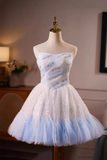 White strapless dress with blue accents on a mannequin against a neutral background