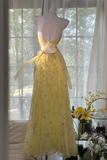 Yellow dress on a mannequin in front of a window with curtains
