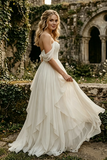 Woman in a white wedding dress standing in front of an old stone building with ivy.