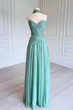 A mint green strapless formal gown displayed on a mannequin in a bright room with white paneled walls and light wood flooring.