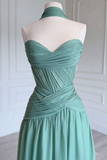A strapless sweetheart halter dress in sage green, displayed on a white mannequin torso against a white paneled wall.