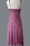 Pink dress with floral embellishments on a mannequin against a gray background