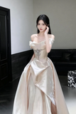 Woman in a white evening gown posing indoors.