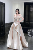 Woman in a white evening gown standing indoors.