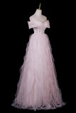 A light pink off-the-shoulder tulle gown displayed on a mannequin against a solid black background.