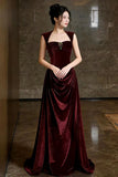 Woman wearing a burgundy velvet gown in an indoor setting