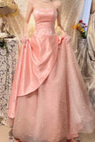Pink strapless gown with a bow detail on a decorative background