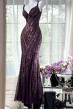 A floor-length, sleeveless evening gown in deep plum purple with shimmering sequined vertical panels, displayed on a mannequin in a bright room with sheer curtains, flowers, and a mirror.