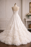 An ivory white ballgown wedding dress with a structured lace bodice and cascading ruffle layers, displayed on a mannequin in an elegant room.
