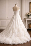 A white strapless ball gown wedding dress with 3D floral appliqués and a beaded back, displayed on a mannequin in an elegant indoor room setting.